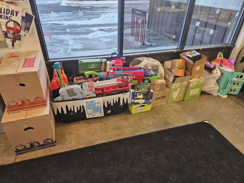 A donation tote and boxes of toys inside a business