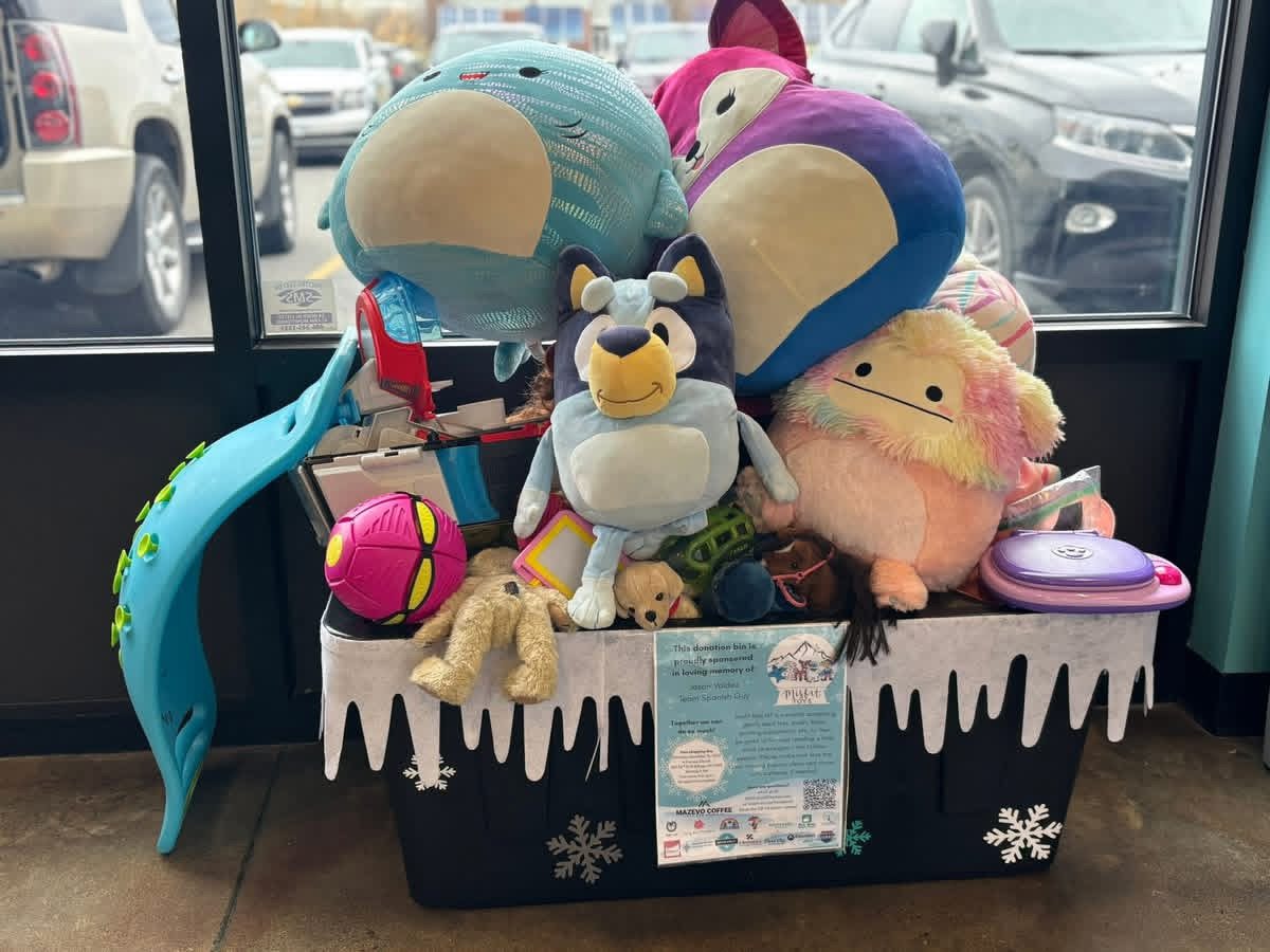 A Misfit Toys donation tote filled with toys at a coffee shop