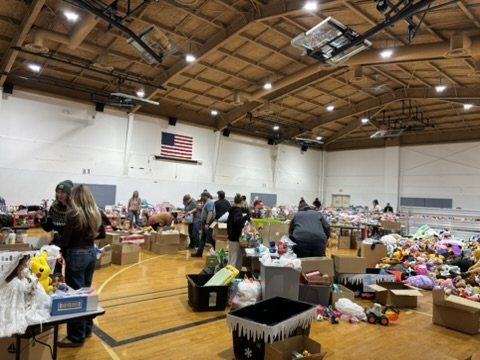 Volunteers sorting toys onto tables in the gym